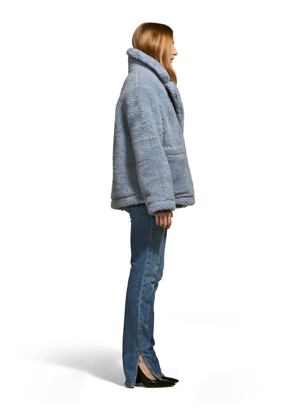 Model wearing the Robin, a hip-length teddy-inspired faux-fur sherpa shell in sky color from the front.